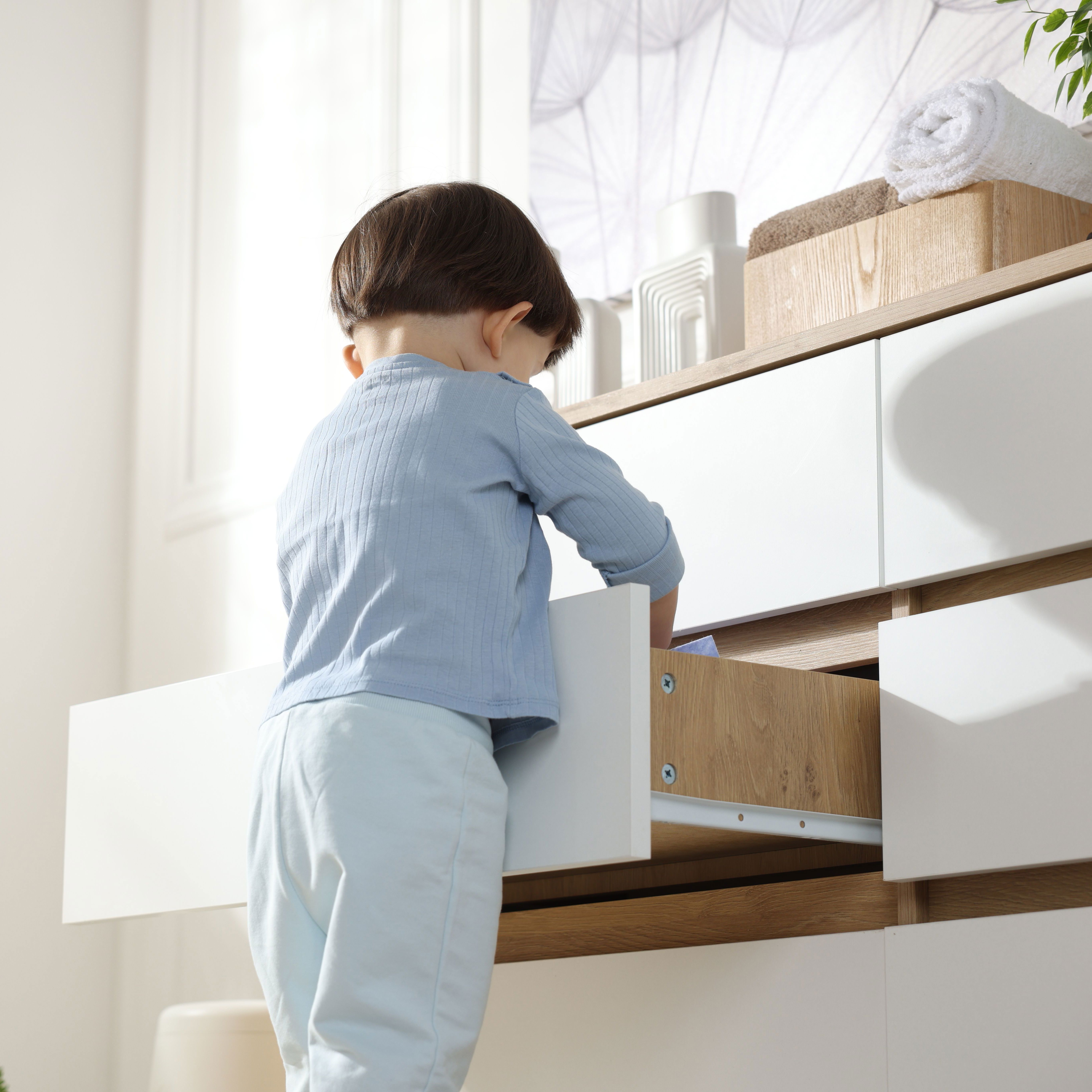 little-boy-opening-drawer-home-low-angle-view-child-danger.jpg